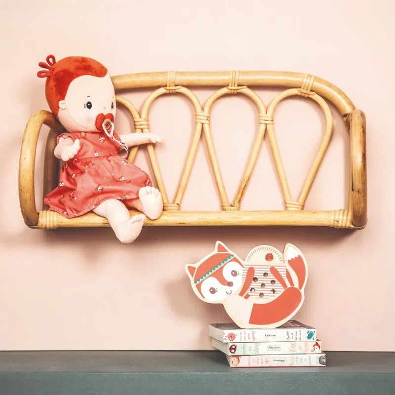 Rose fabric doll on rattan shelf styled with children's books and fox decor