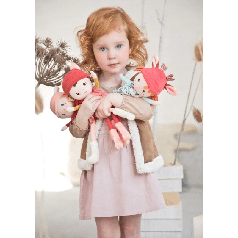 Child hugging Lilliputiens Stella fabric doll with coral antler hat and floral dress