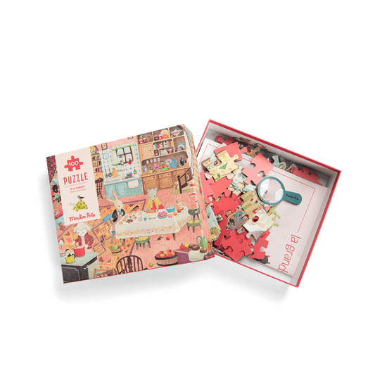 Open Moulin Roty puzzle box displaying 100 pieces, magnifying glass, and poster
