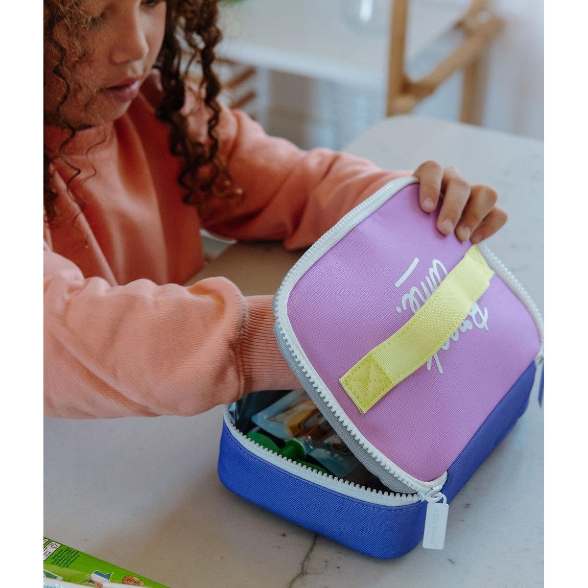 Close-up of two-tone purple blue lunch bag interior with food items