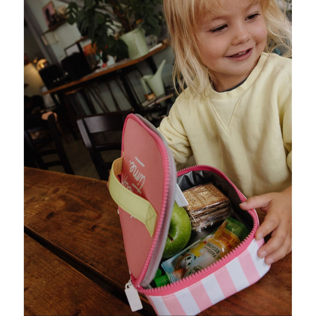 Insulated lunch bag filled with apple crackers and juice pouch
