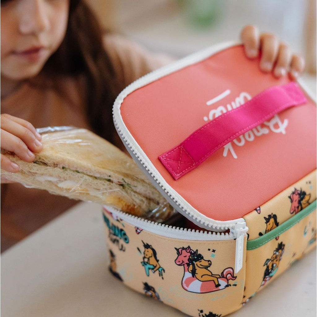 Close-up of hands placing sandwich in unicorn pattern lunch bag