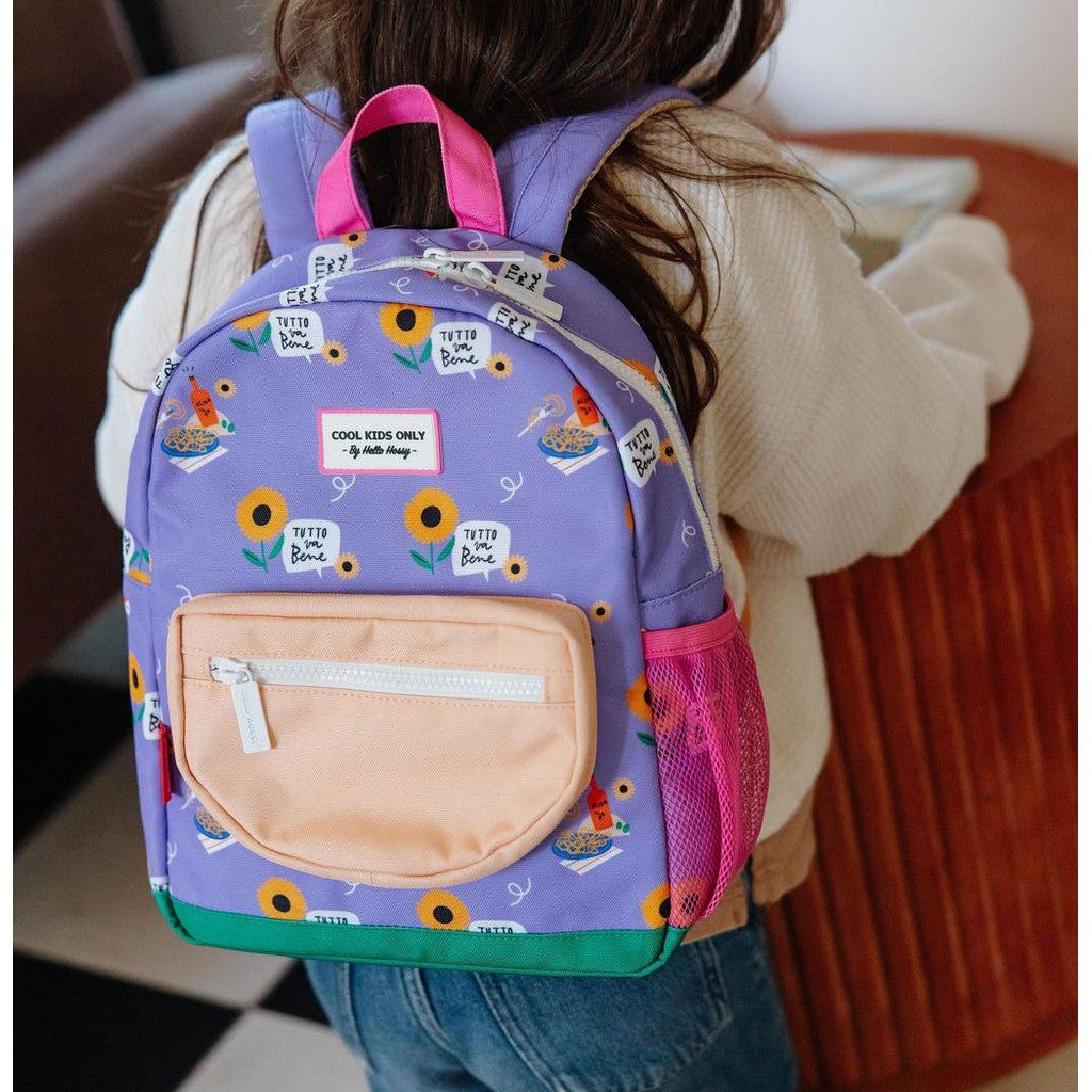 Child wearing purple sunflower patterned Hello Hossy backpack with adjustable straps
