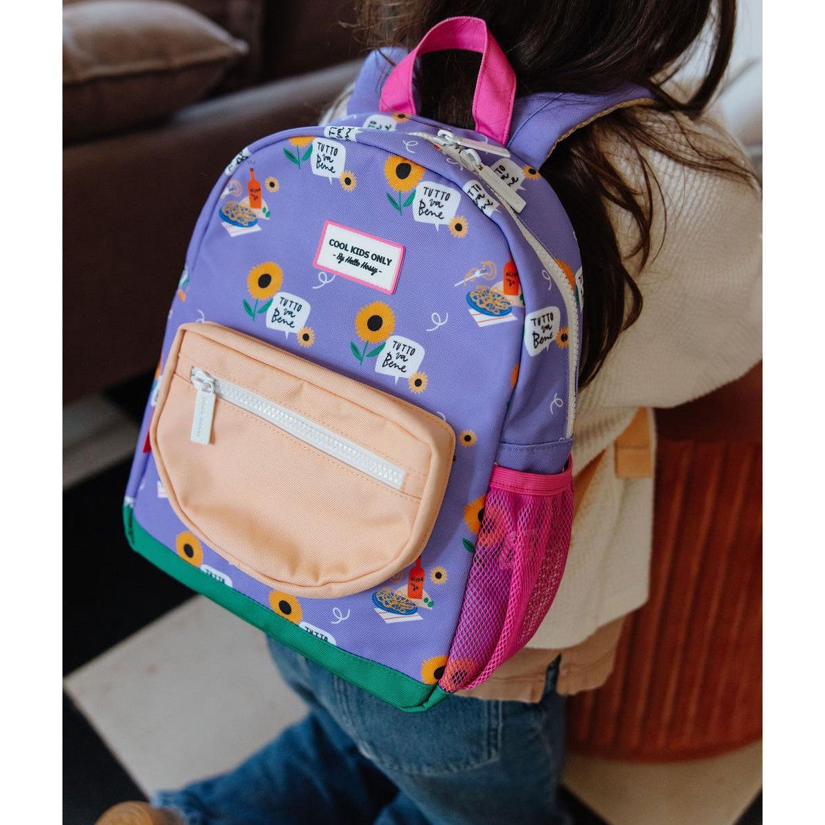 Back view of child in purple Hello Hossy backpack with green base trim and pink handle
