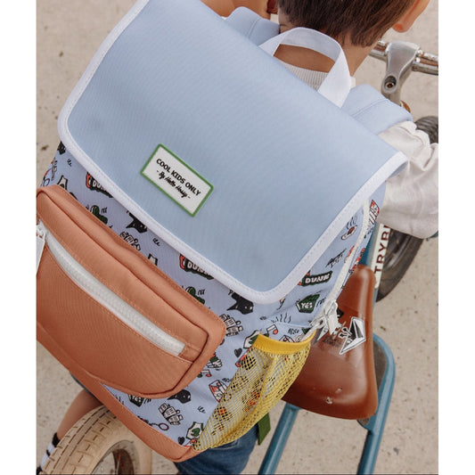 Close-up of Hello Hossy backpack flap on child riding bicycle