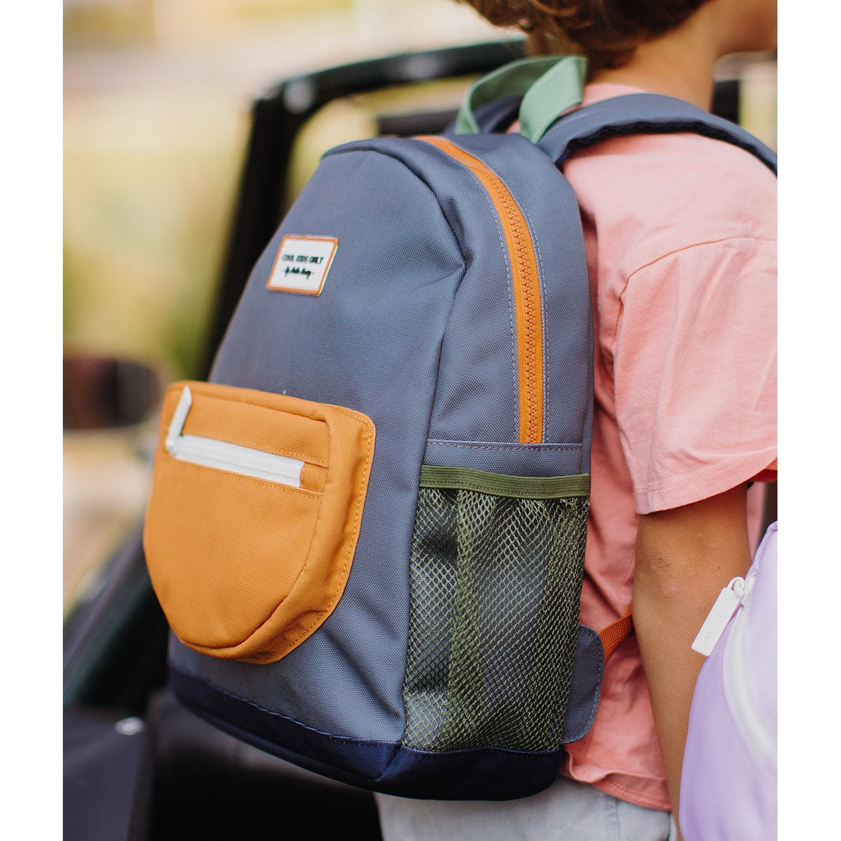 Close-up of gray-blue children's backpack with orange trim and side mesh pocket