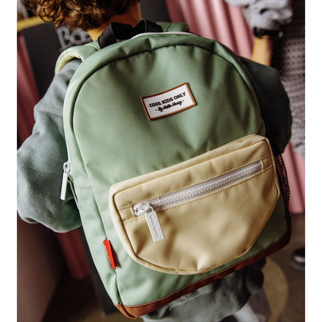 Green Mini Pistache backpack with white zipper and Hello Hossy brand tag