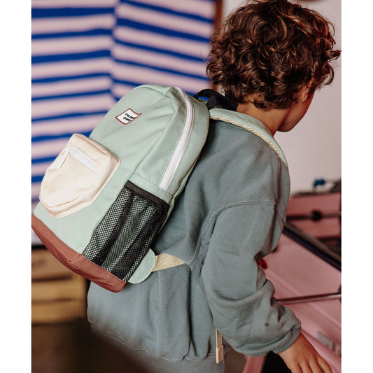 Child modeling green Mini Pistache backpack with beige rope-trimmed straps