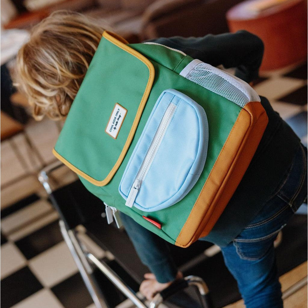 Child wearing olive green square backpack with mustard trim and mesh pocket
