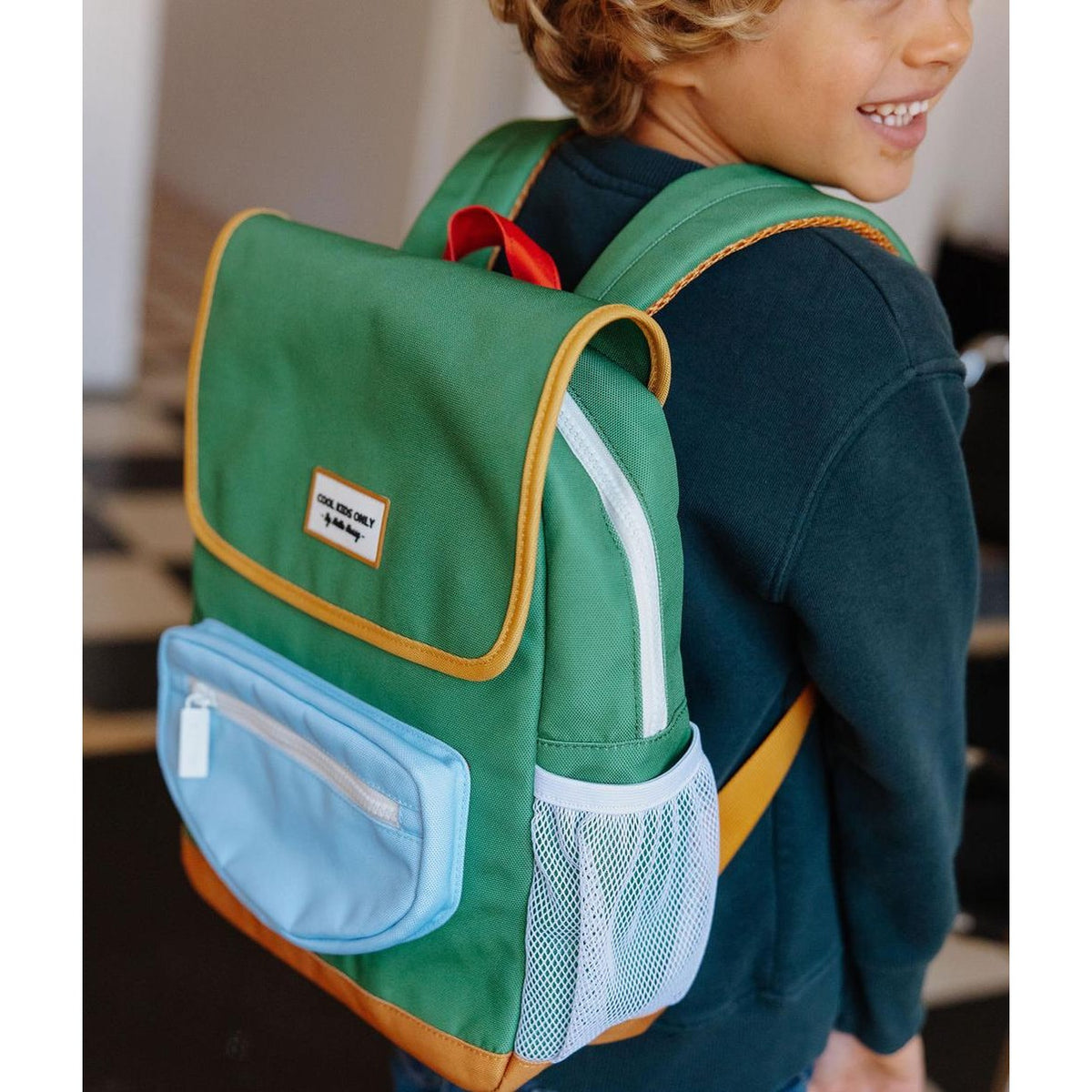 Smiling child modeling green Hello Hossy mini backpack for school or play