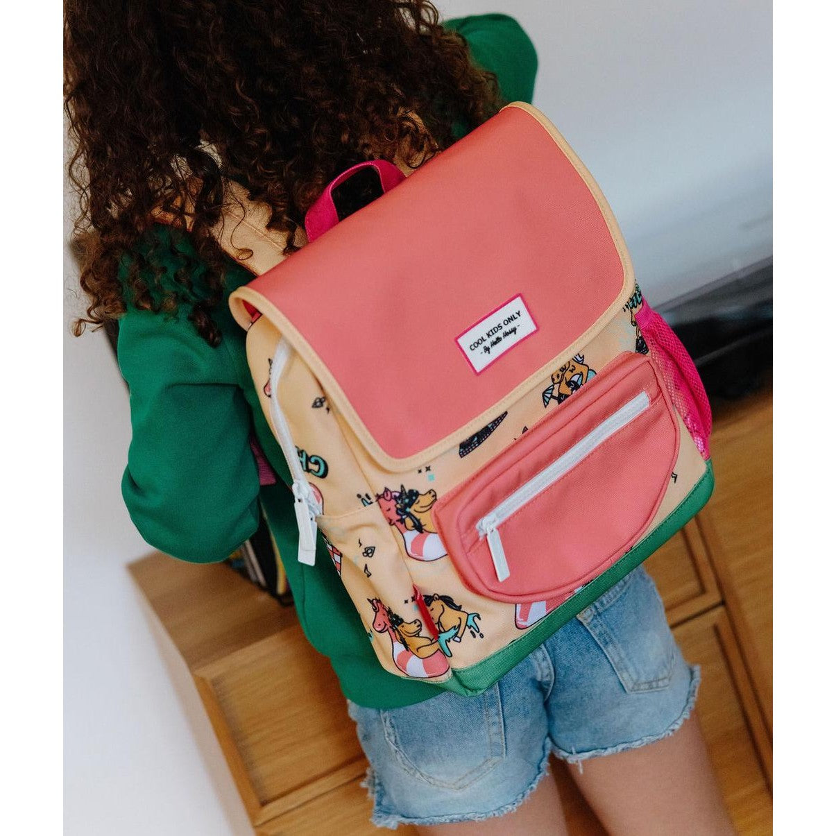 Backpack worn by child showing yellow unicorn design and pink accents
