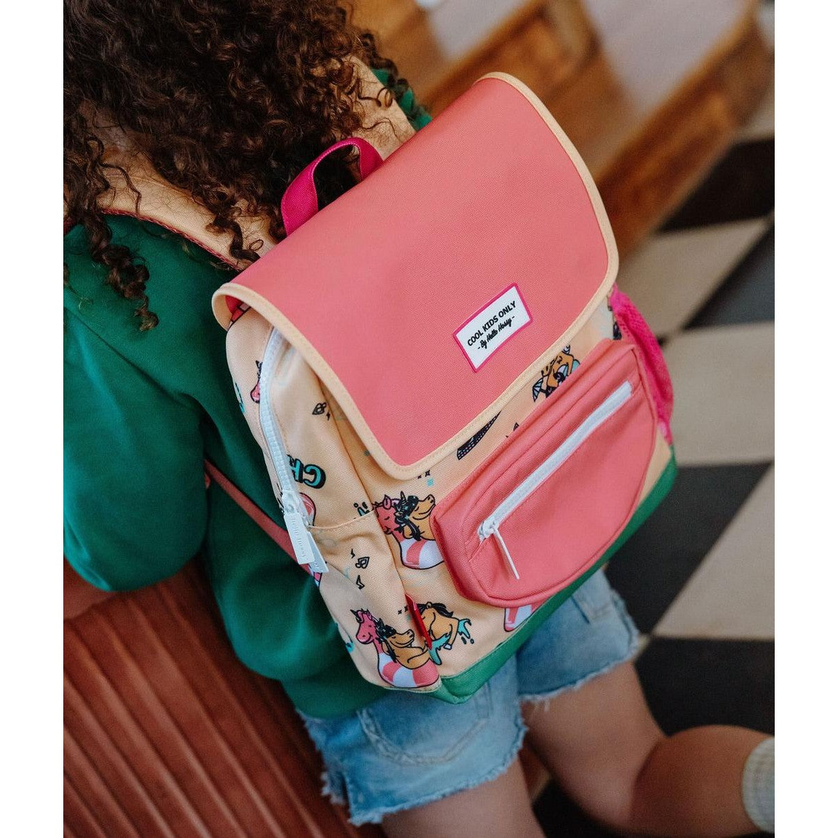 Child wearing yellow unicorn square backpack for school or play
