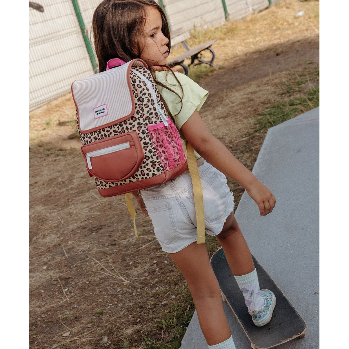 Leopard print kids backpack side view showing pink mesh pocket and label