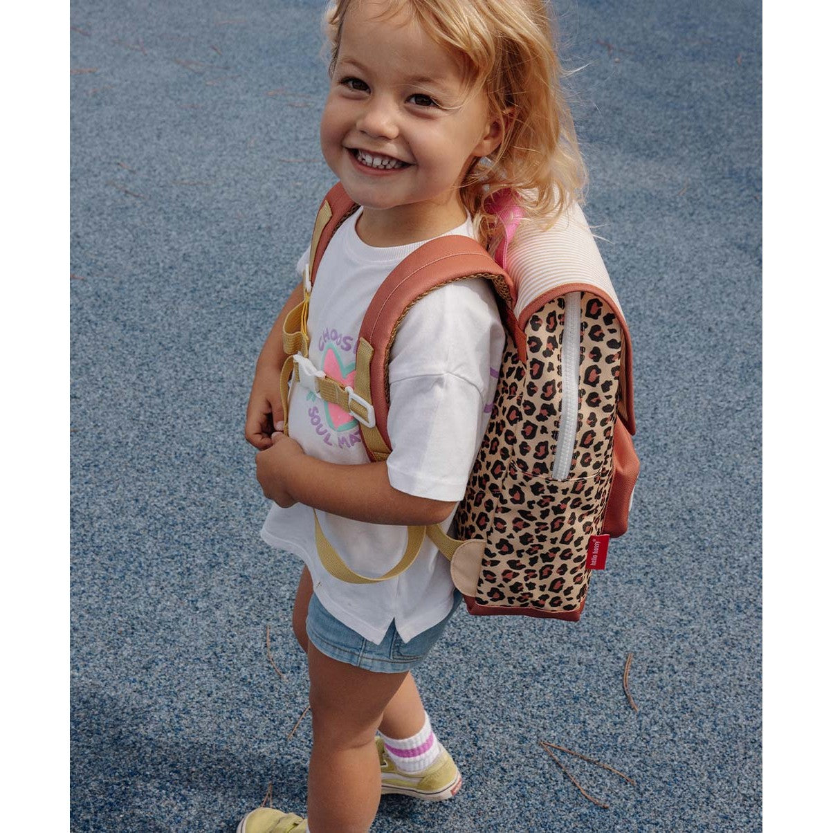 Blonde girl wearing beige leopard print backpack with pink details