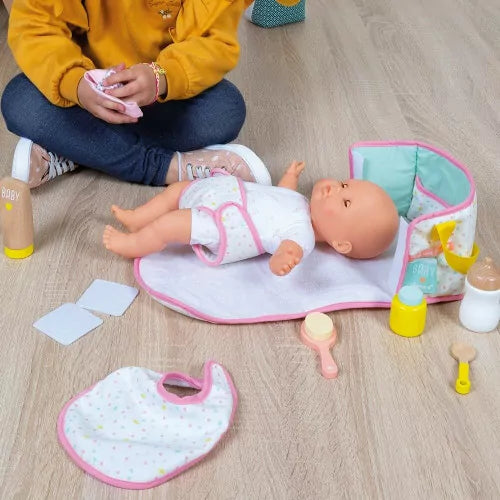 Child playing with Janod nursery doll changing bag and accessories