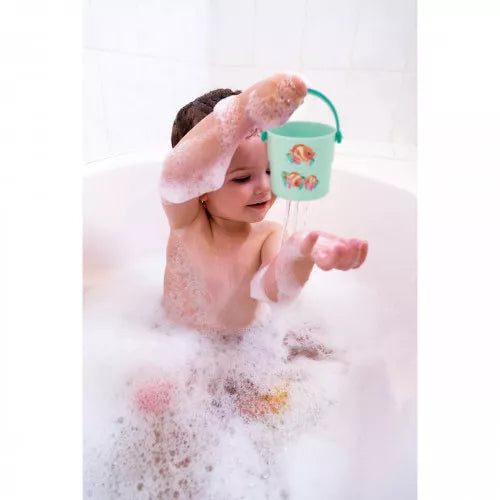 Toddler pouring water from blue Janod sea creature bath bucket in tub