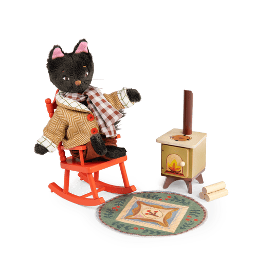 Plush cat figure in herringbone coat sitting on orange rocking chair by stove