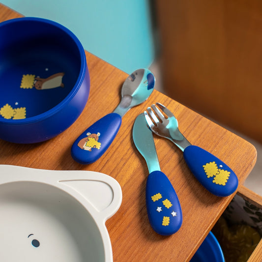 Puce & Pilou toddler cutlery set on wooden table next to hedgehog bowl and animal plate