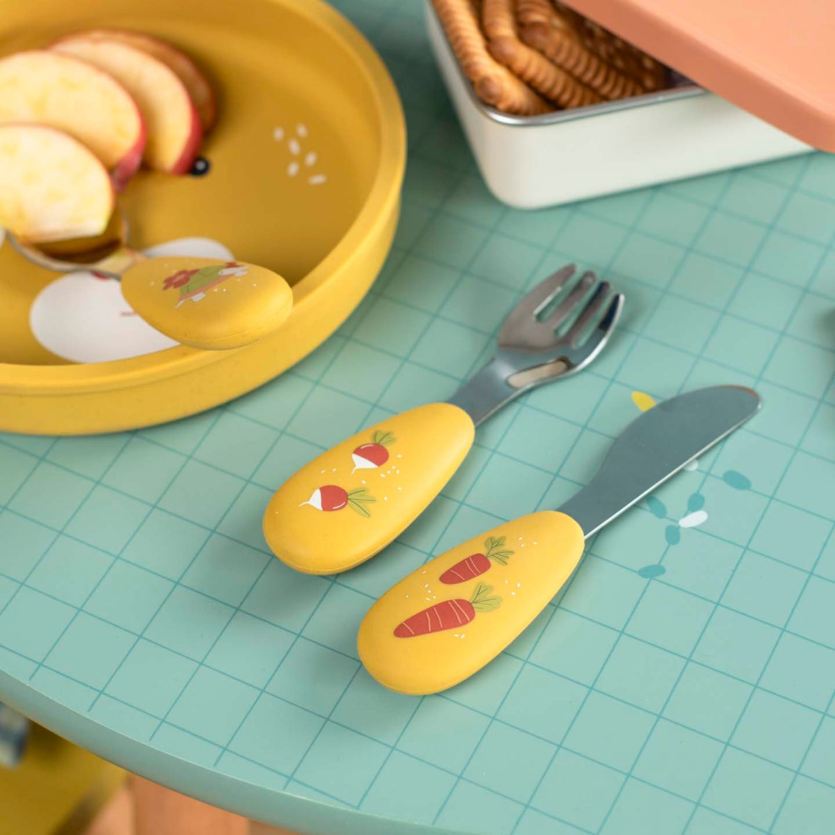 Children's stainless steel and silicone cutlery set with vegetable illustrations on table