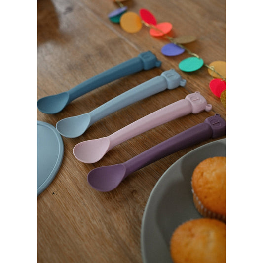 Multi-color Lili l'Ours silicone baby spoon set on wooden table