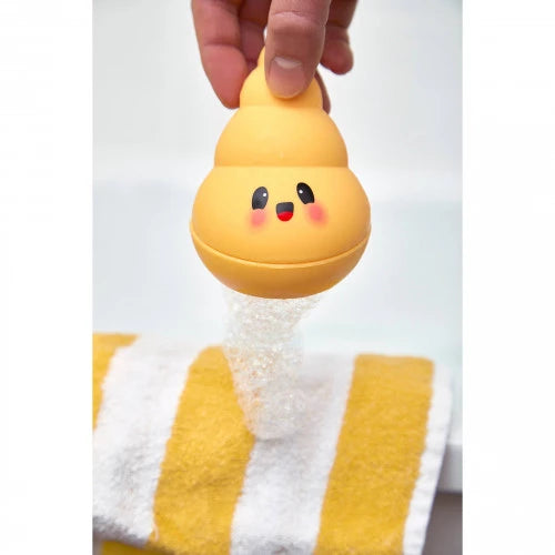 Child blowing bubbles from yellow spiral bath toy in tub