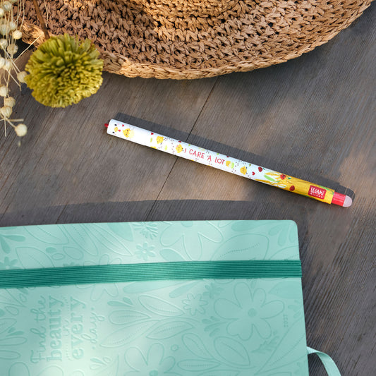 Legami Stiletto pen with chick pattern lying next to mint-green floral notebook