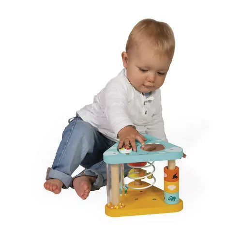 Toddler playing with Janod Tropik wooden activity triangle on white floor