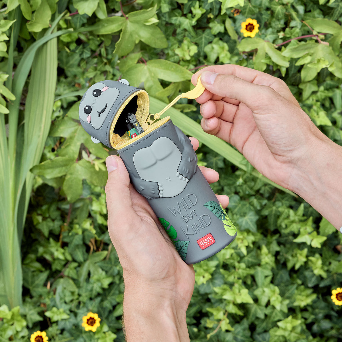 Grey silicone gorilla pencil case held in hands, showing removable head lid and 'Wild but Kind' design