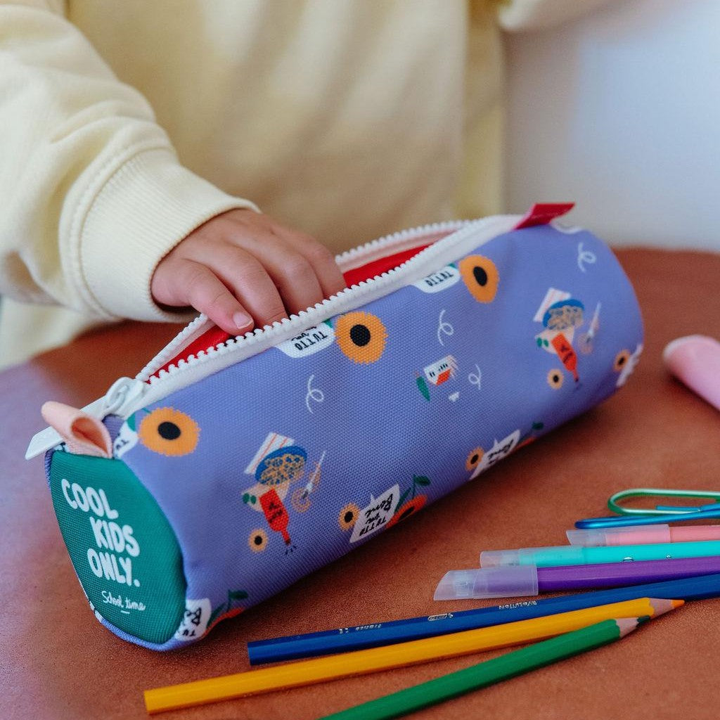 Hand reaching into open purple sunflower pencil case with colored pencils nearby