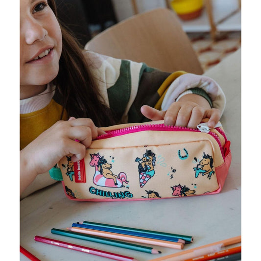 Side view of child holding beige unicorn patterned pencil case