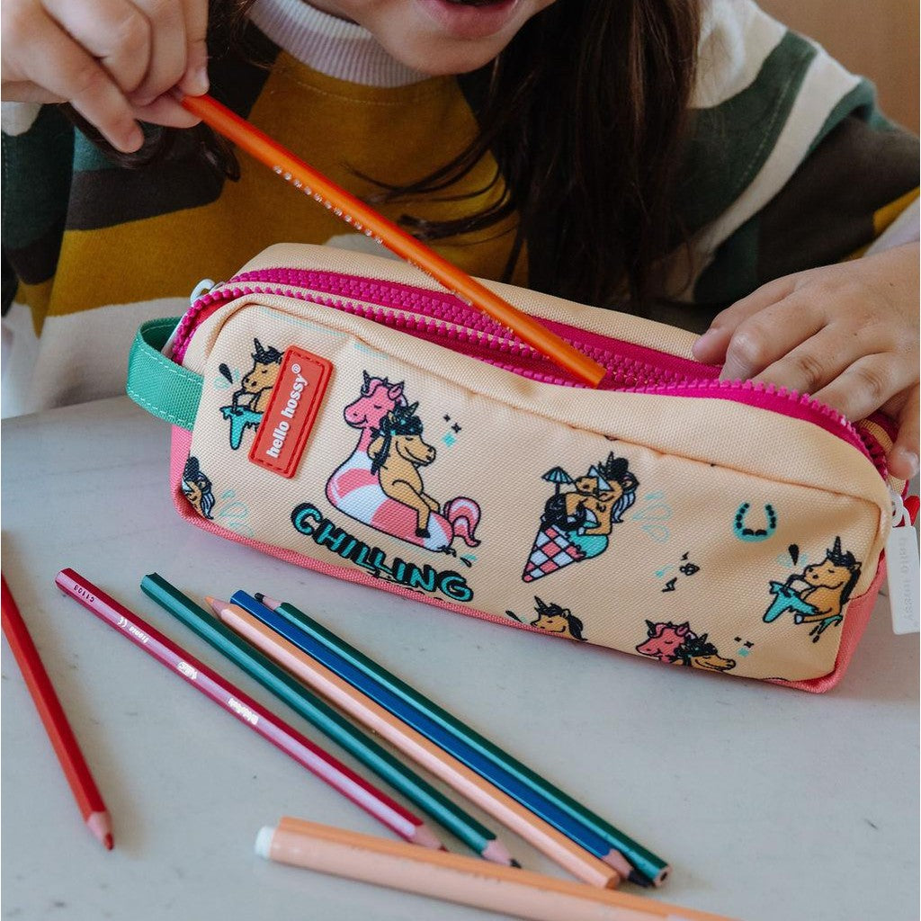 Child using beige Hello Hossy unicorn pencil case with pink zipper