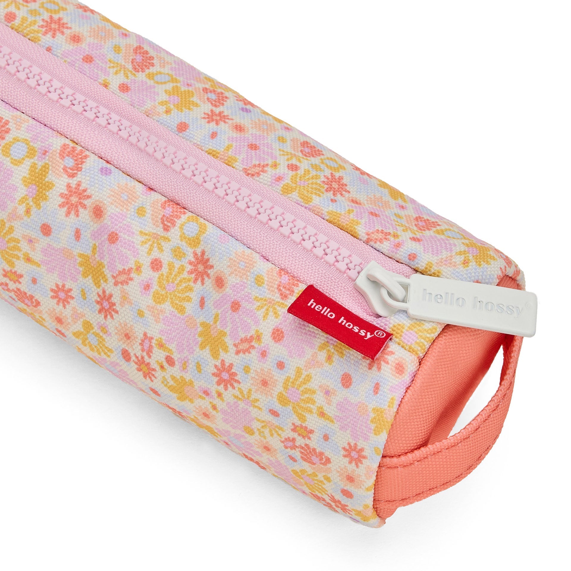 Close-up of Hello Hossy pencil case zipper with pastel floral print and coral end cap