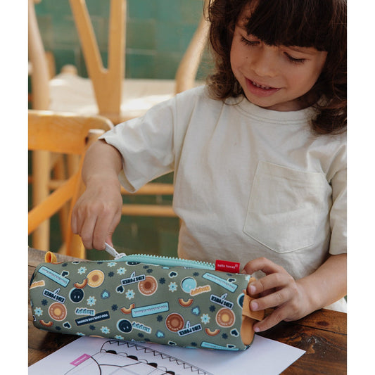 Child opening green cylindrical pencil case with smiley face pattern