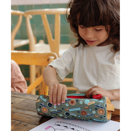 Child unzipping green smiley face pencil case on wooden table