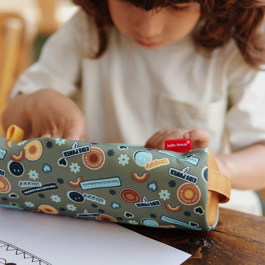 Close-up of child hands using green patterned school pencil case