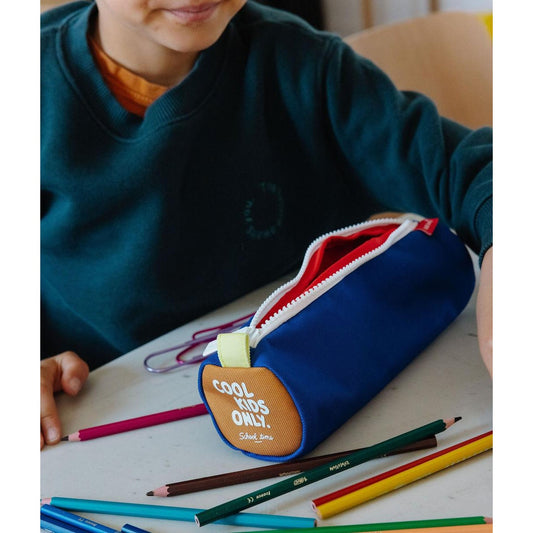 Blue kids stationery bag with red lining surrounded by colored pencils on desk