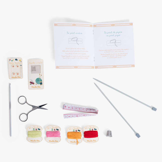 Children's sewing kit accessories including needles, thread spools, scissors, and thimble