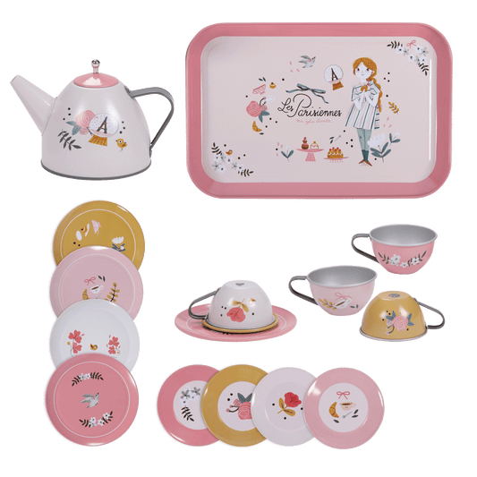 Disassembled Moulin Roty tea set components showing teapot, pink tray, and stacked patterned plates