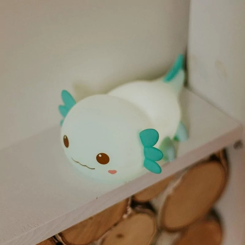 Illuminated blue axolotl night light casting soft glow on shelf
