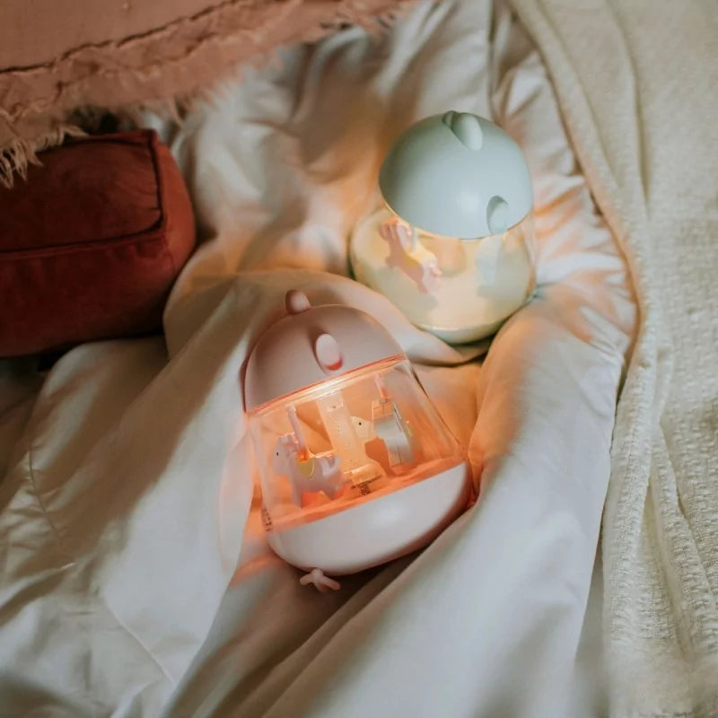 Pink and sage green LED night light with carousel horse design on bedding
