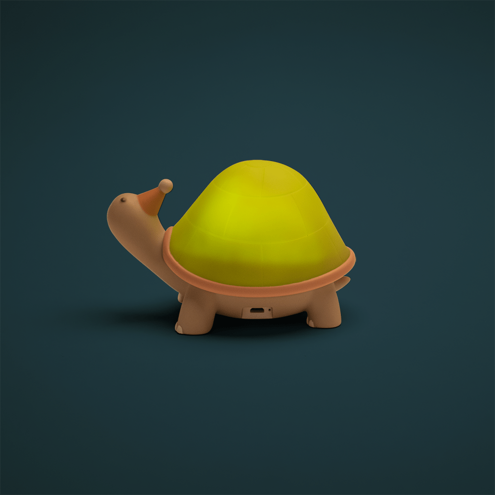 Illuminated turtle nightlight glowing warm yellow in dark room