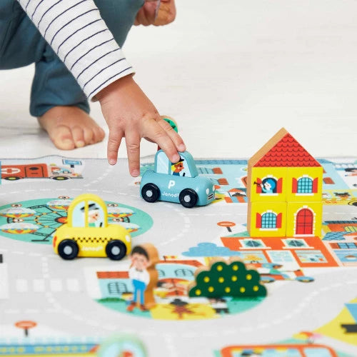 Child playing with Janod blue wooden police car on play mat